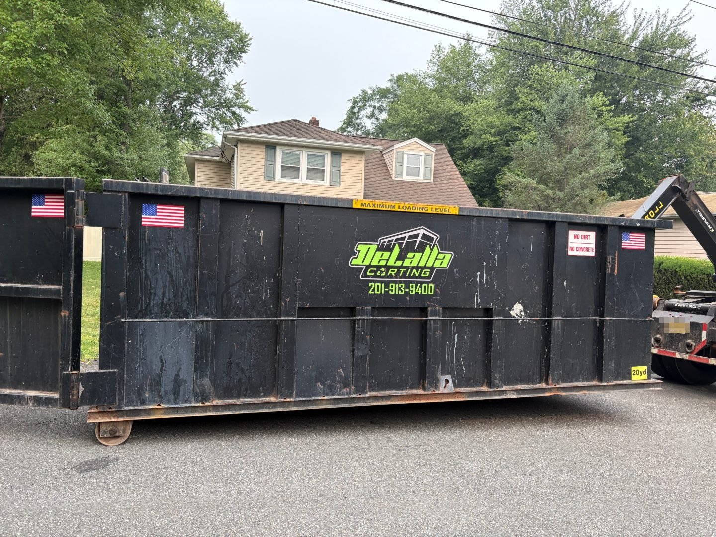 Side view of a 20-yard dumpster on a street in Congers, NY, showing the maximum loading level line.