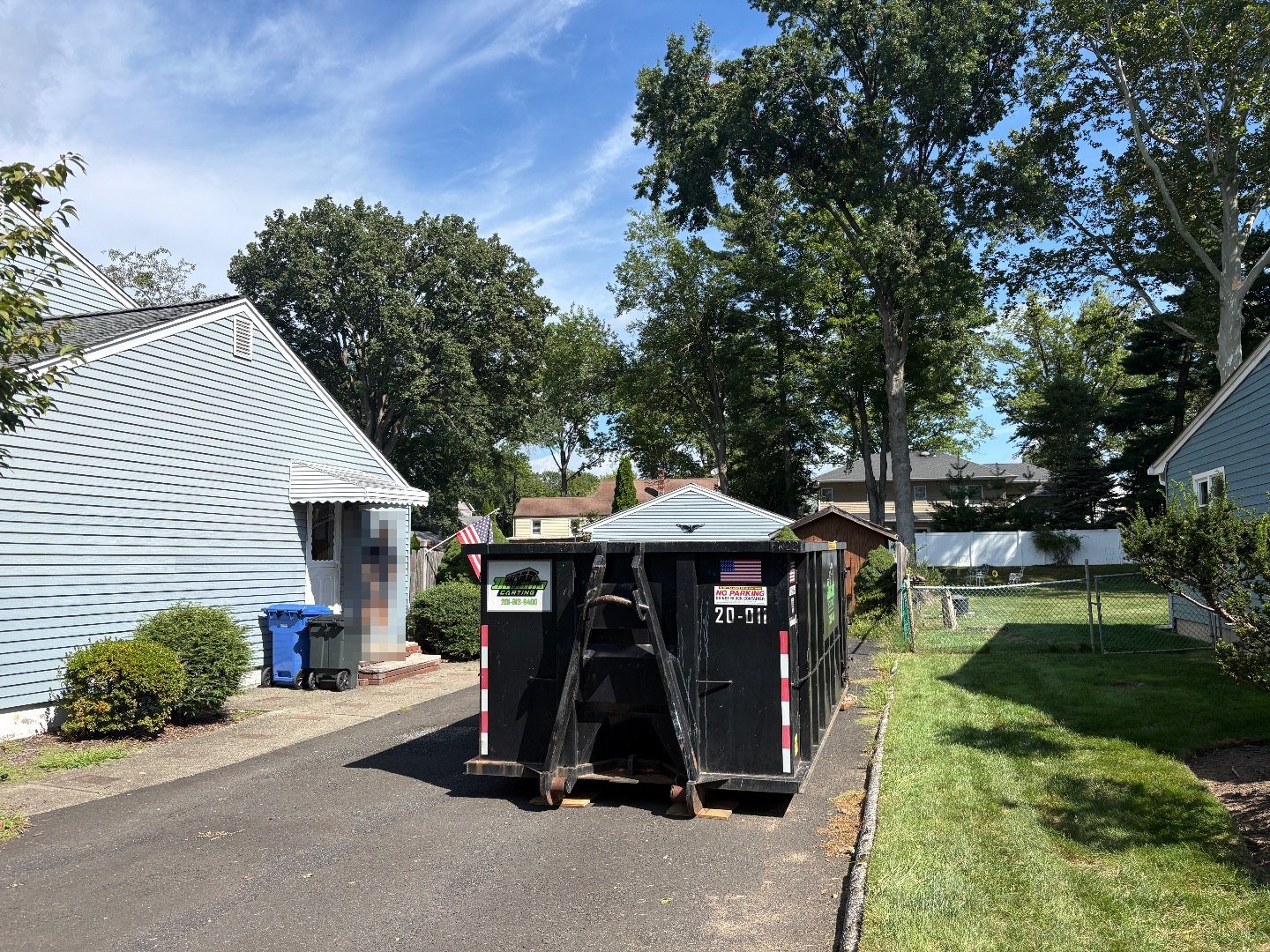 20-yard dumpster on the side driveway of a cape in Paramus, NJ.