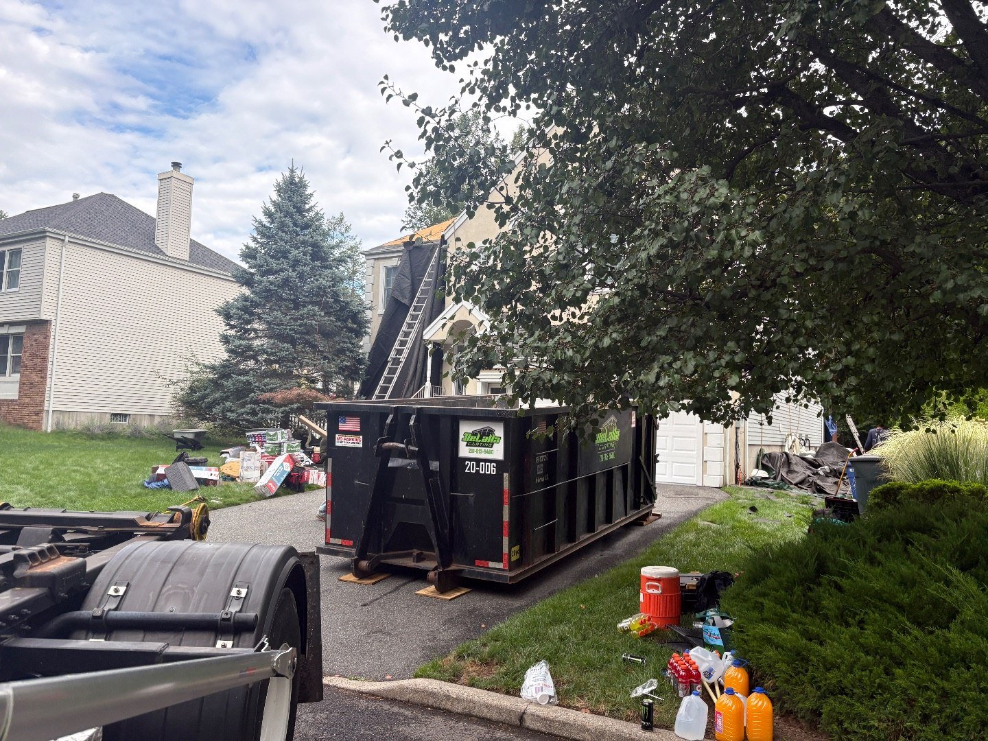 20-yard dumpster at a River Vale, NJ roofing job, shingle bundles staged on the lawn.