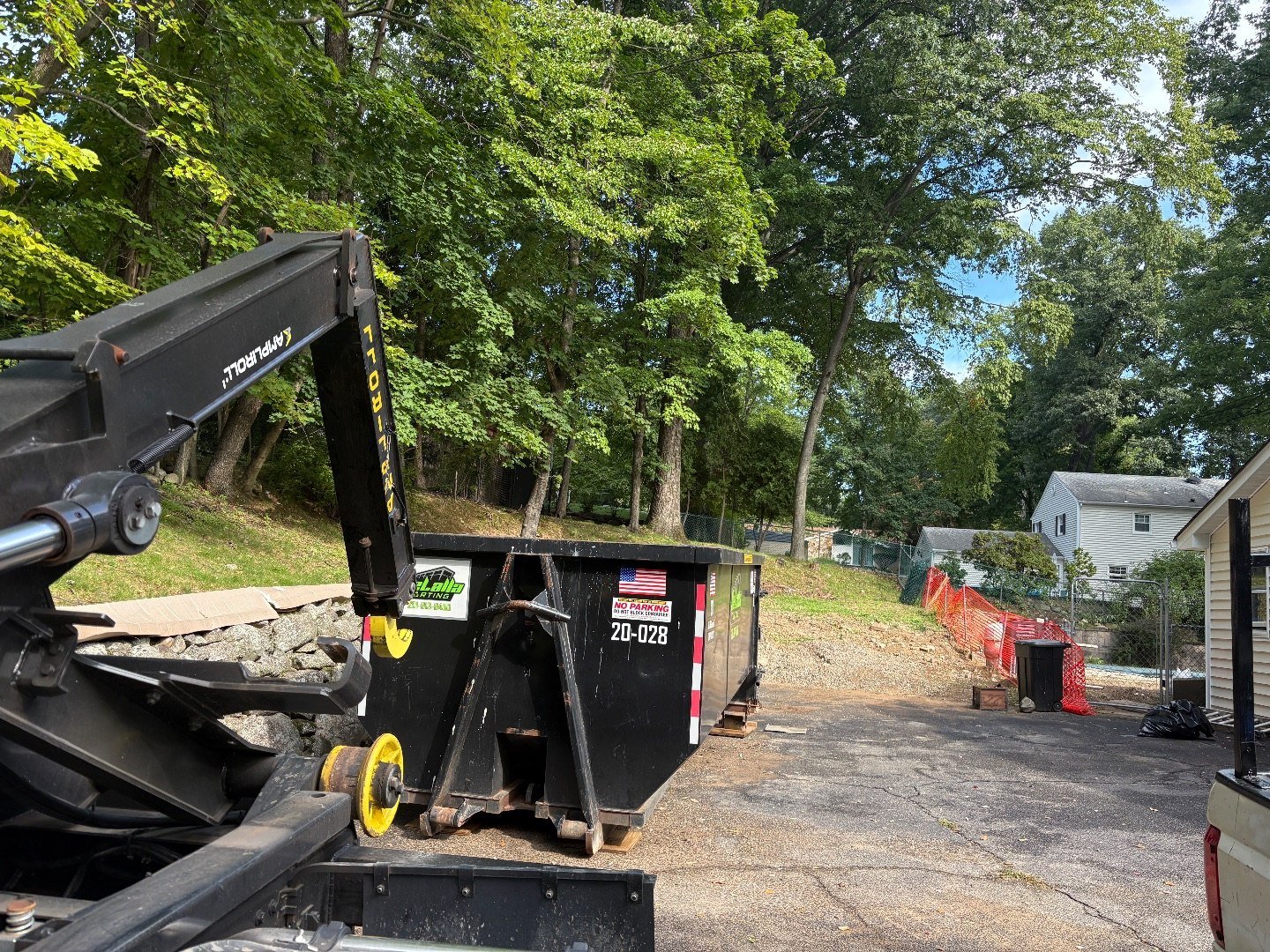 20-yard dumpster placed on a sloped lot with a retaining wall in River Vale, NJ.