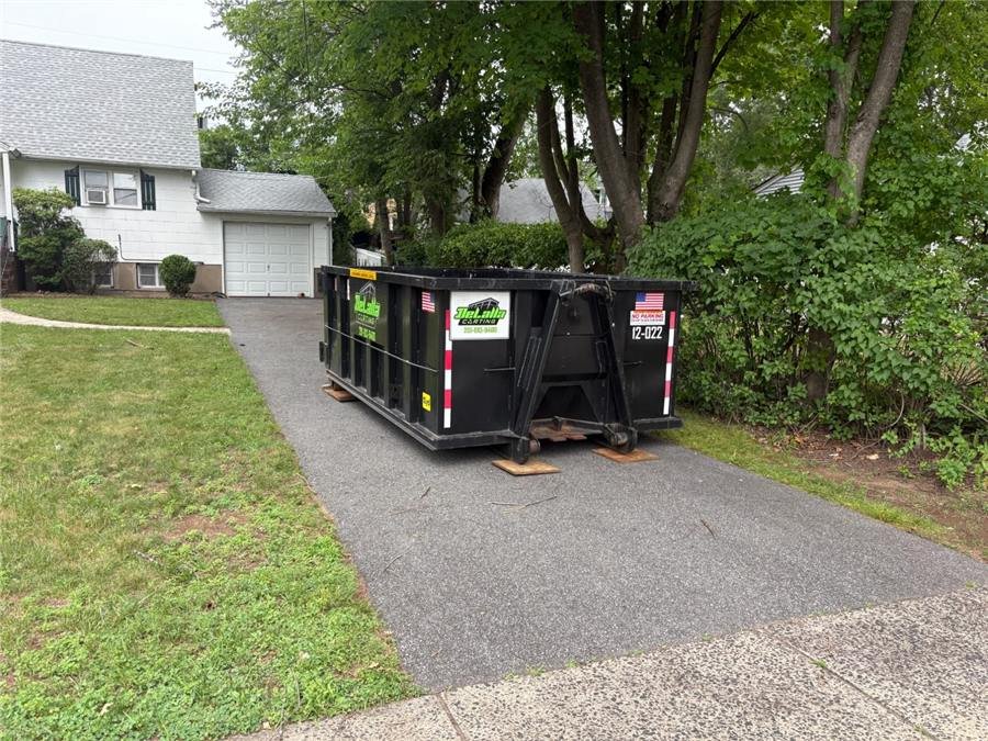 12-yard dumpster on protection boards in a one-car driveway in New Milford, NJ