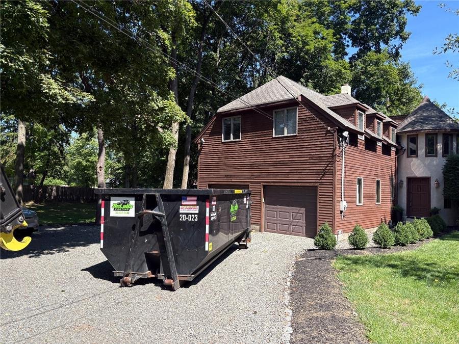 20-yard dumpster on a gravel driveway in Westwood, NJ