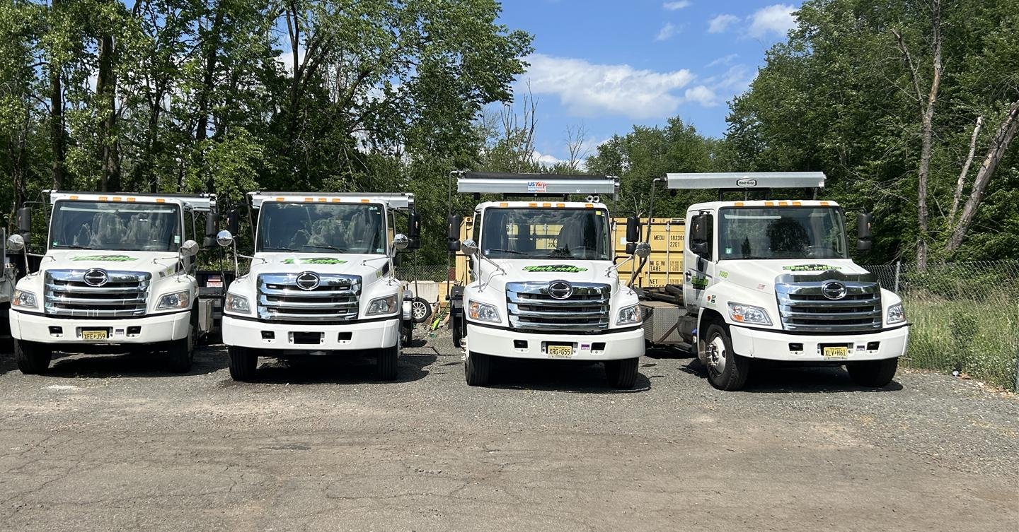 Four DeLalla Carting roll-off trucks in the yard