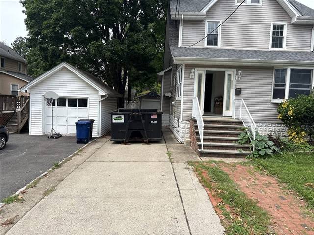12-yard dumpster in a narrow shared driveway in Dumont, NJ
