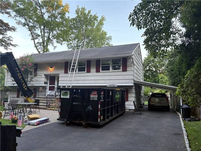 20-yard dumpster beside a split-level in River Vale, NJ